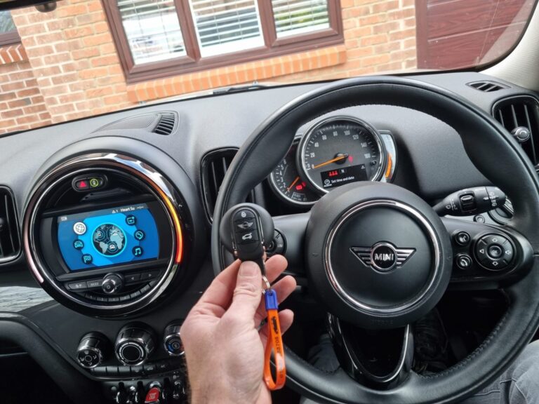 Locksmith holding Mini key in a car