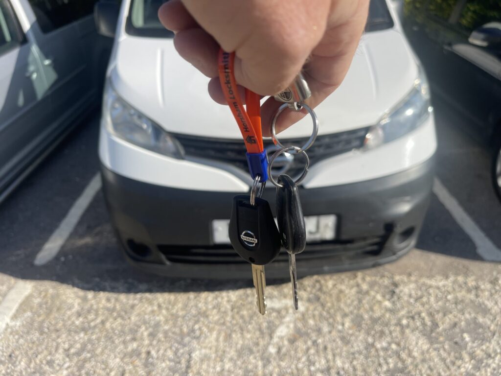 car keys held up in front of a van