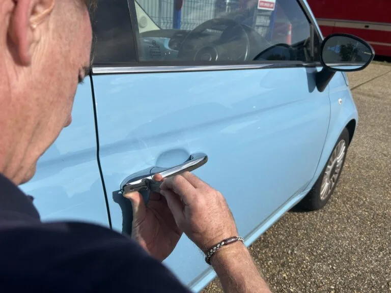 A locksmith working on a car door