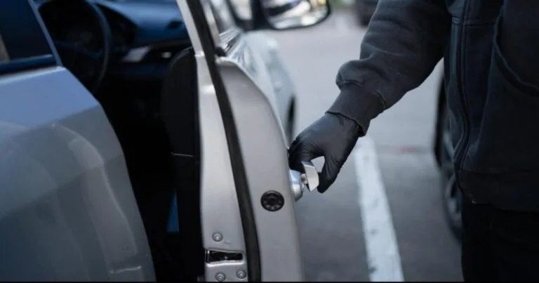 Car thief opening a car door