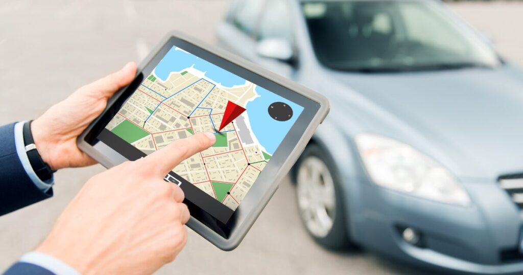 GPS tracker software shown on tablet, in front of a car