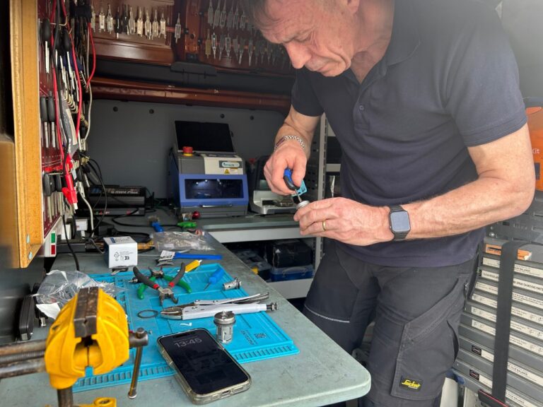 Locksmith in a van holding an ignition barrel